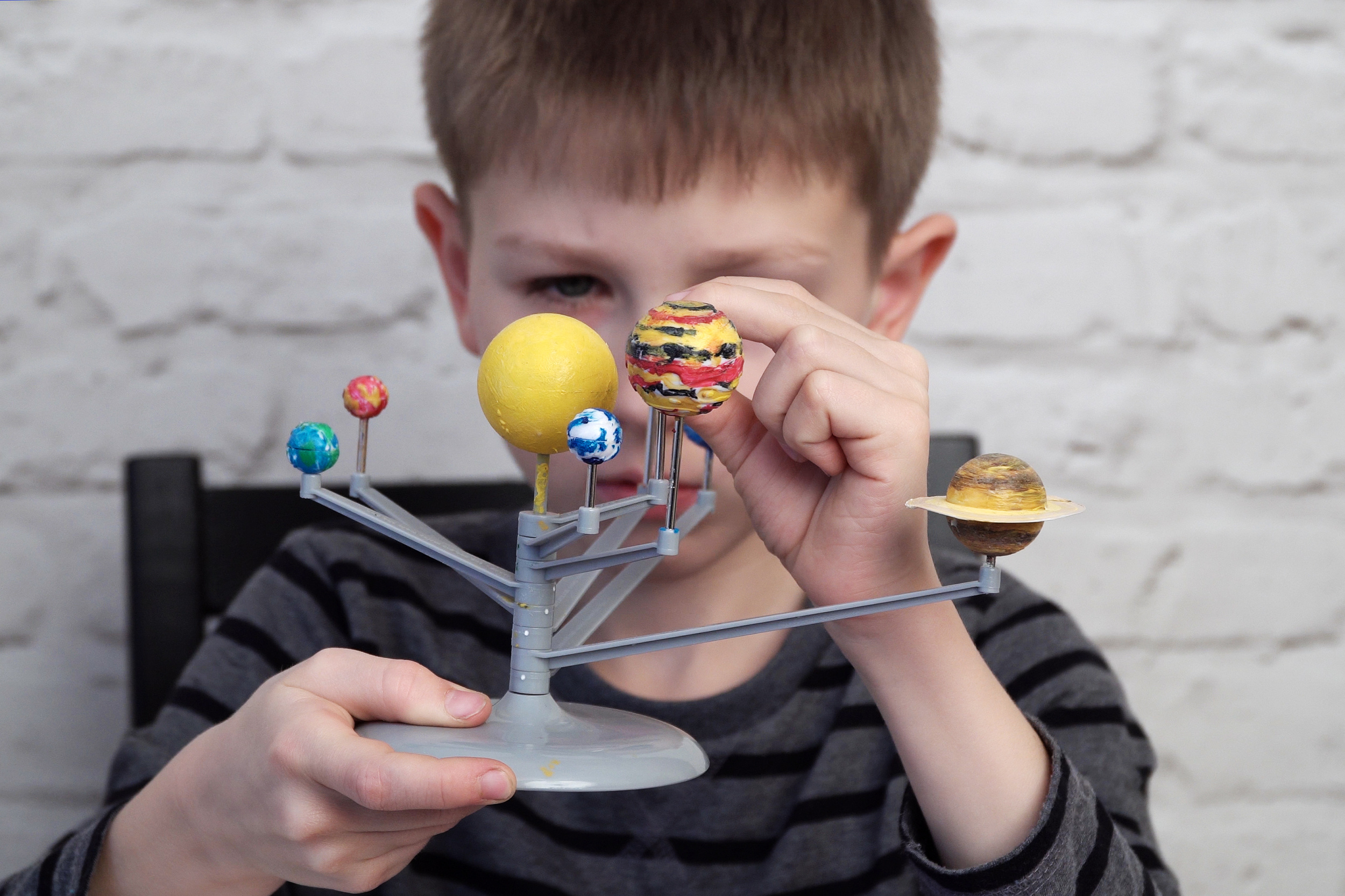 01 little-boy-is-playing-with-model-solar-system.jpg